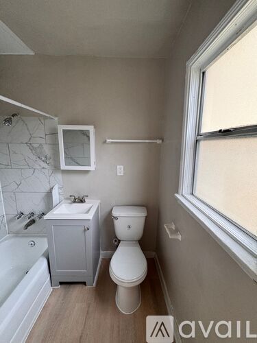 A small bathroom with a toilet, sink, and bathtub.