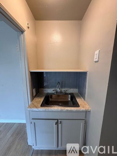 A small kitchen with a sink and a cabinet.