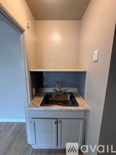 A small kitchen with a sink and a cabinet.