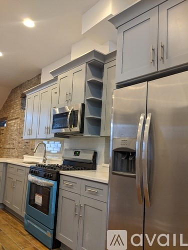 A kitchen with a blue oven and a stainless steel refrigerator.