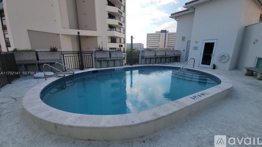 A small round pool with a concrete edge and a metal railing around it.