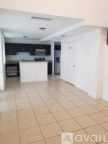 A kitchen with white cabinets and a tiled floor.