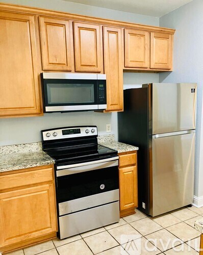 A kitchen with wooden cabinets and a black stove top oven.