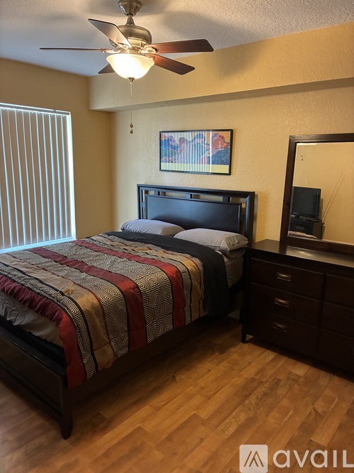 A bedroom with a bed, dresser, and mirror.
