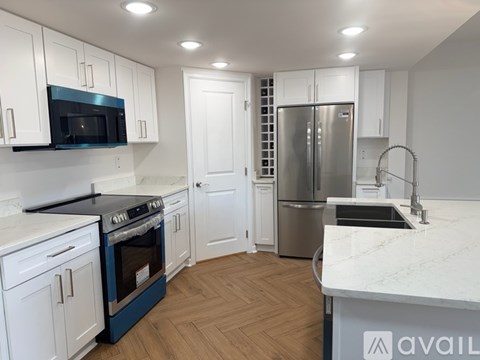 A kitchen with white cabinets and a blue oven.