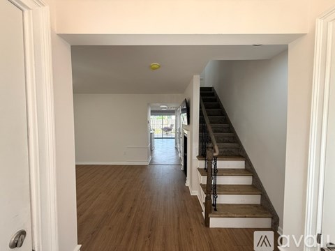 A hallway with wooden floors and a staircase.