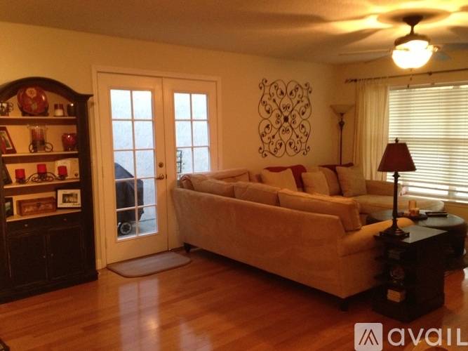 A living room with a couch, a table, and a ceiling fan.
