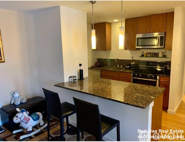 A kitchen with granite countertops and wooden cabinets.