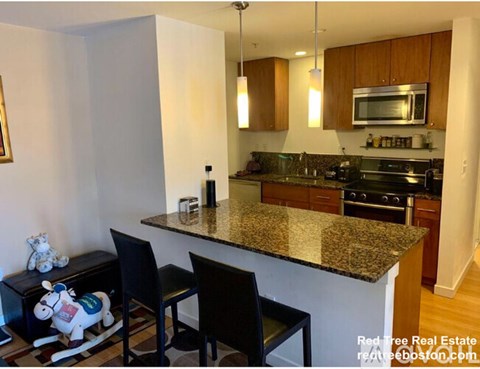 A kitchen with granite countertops and wooden cabinets.