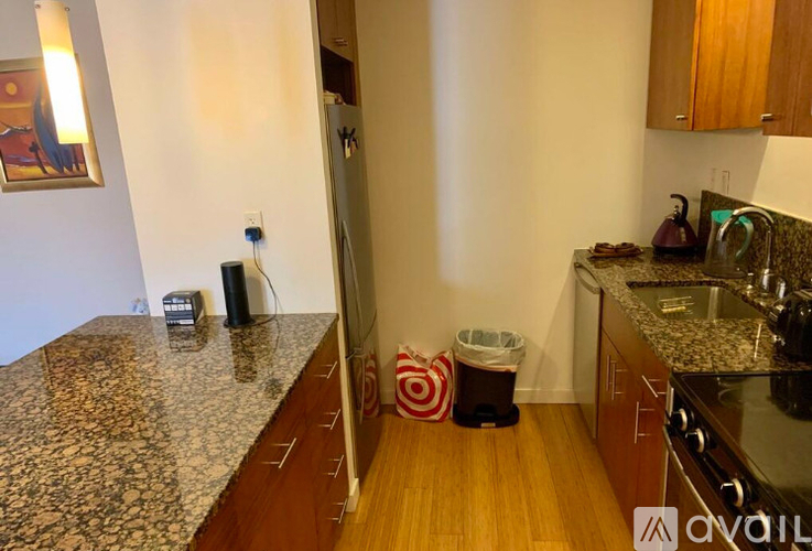 A kitchen with granite countertops and wooden floors.