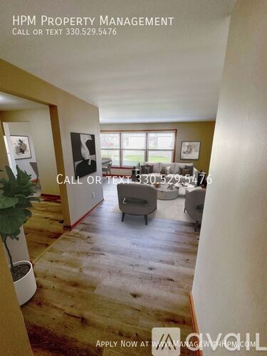 A living room with a couch and a chair, and a sign that says "HPM Property Management".