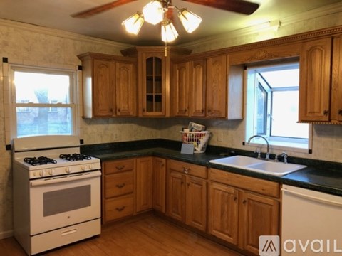 A kitchen with wooden cabinets and a white stove top oven.