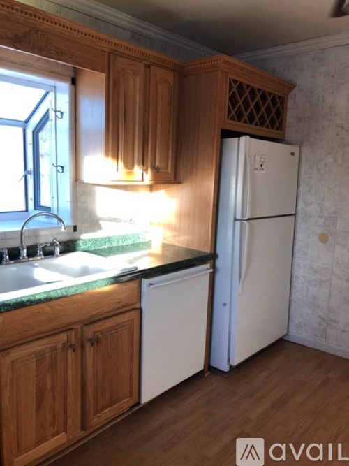 A kitchen with wooden cabinets and a white fridge.