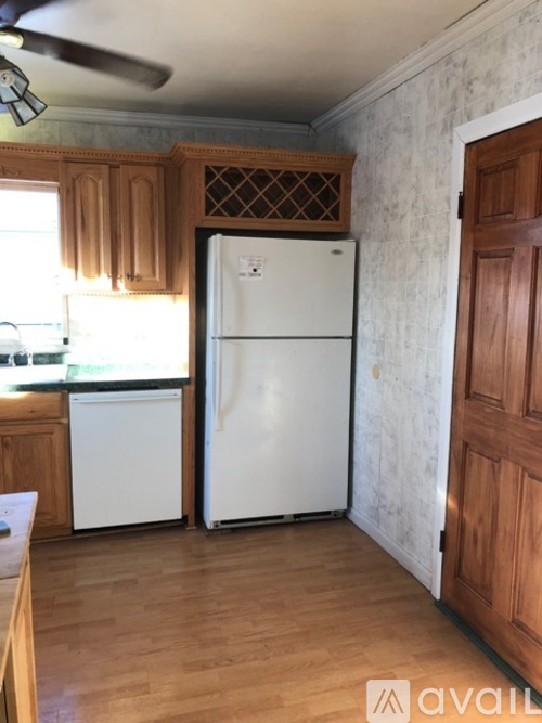 A kitchen with a white fridge and wooden cabinets.