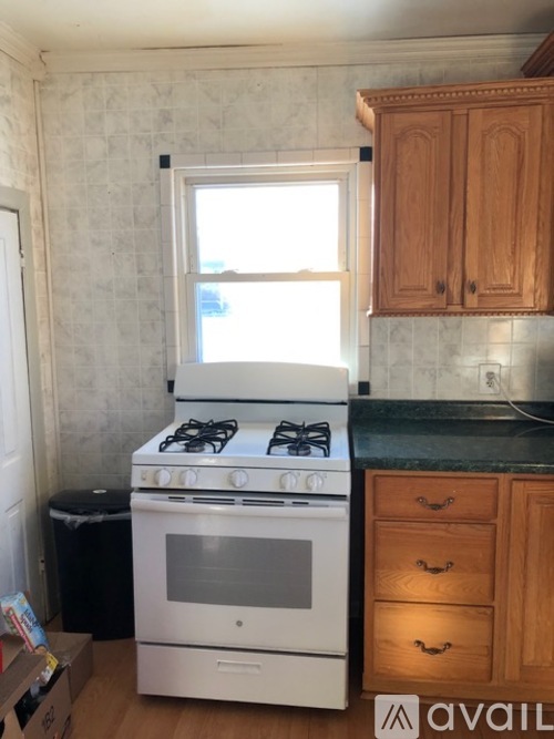 A white stove in a kitchen with wooden cabinets.