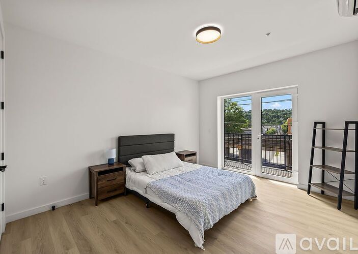 A bedroom with a bed, nightstand, and sliding glass doors.