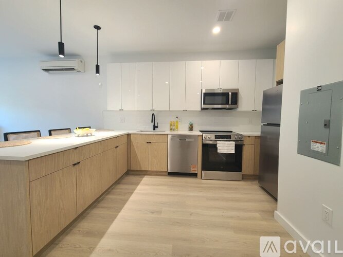 A kitchen with wooden cabinets and stainless steel appliances is available for rent.