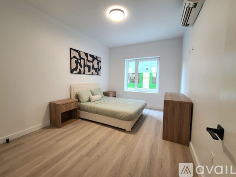 A bedroom with a bed, nightstand, and a wooden bench.