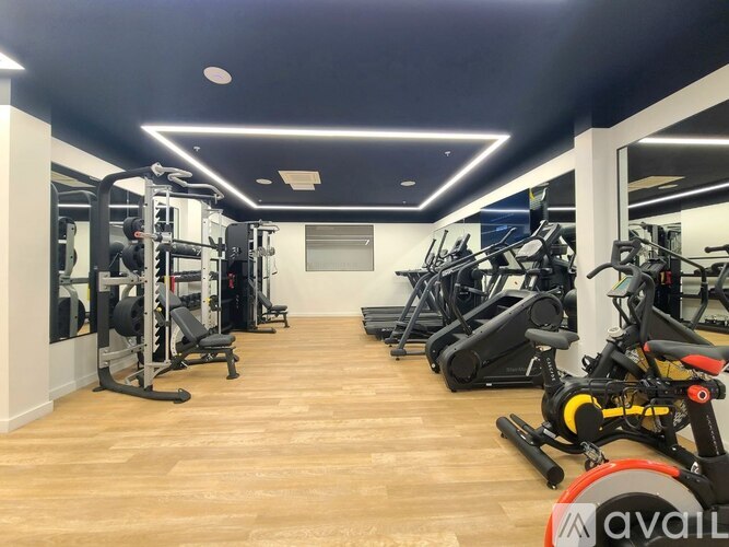A gym with a variety of equipment including treadmills, weights, and exercise bikes.
