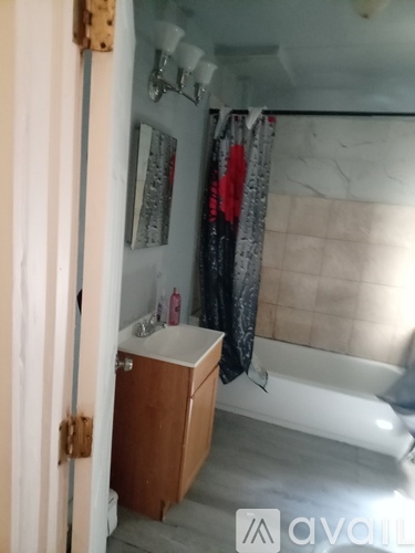 A bathroom with a white tub and a wooden cabinet.