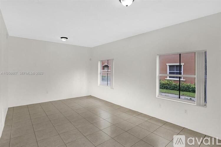 A room with a tiled floor and a window showing a view of a building.