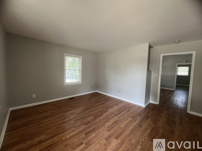 A room with wooden flooring and a window.
