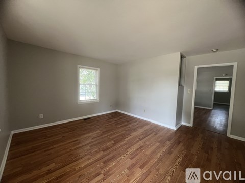 A room with wooden flooring and a window.