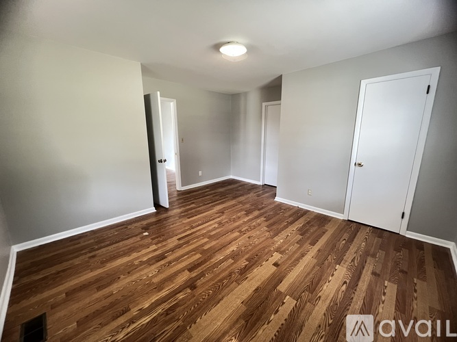 A room with wooden flooring and white walls.