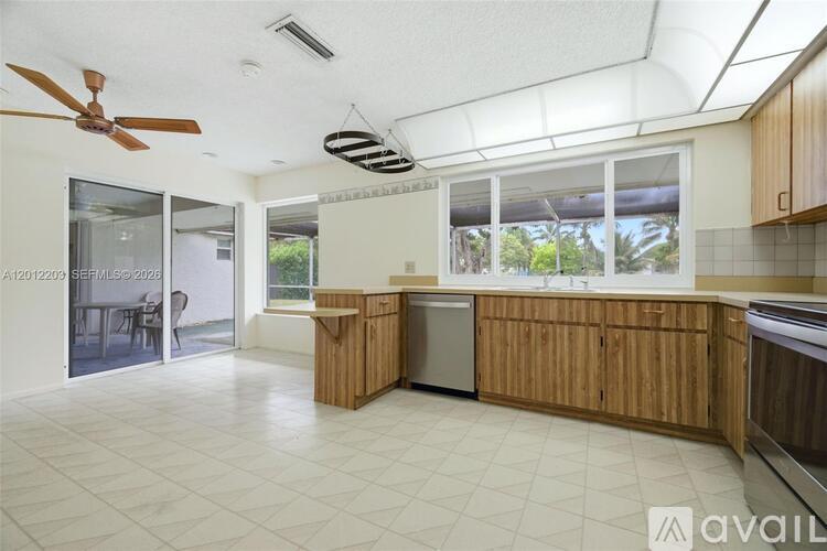 A kitchen with wooden cabinets and a fan on the ceiling.