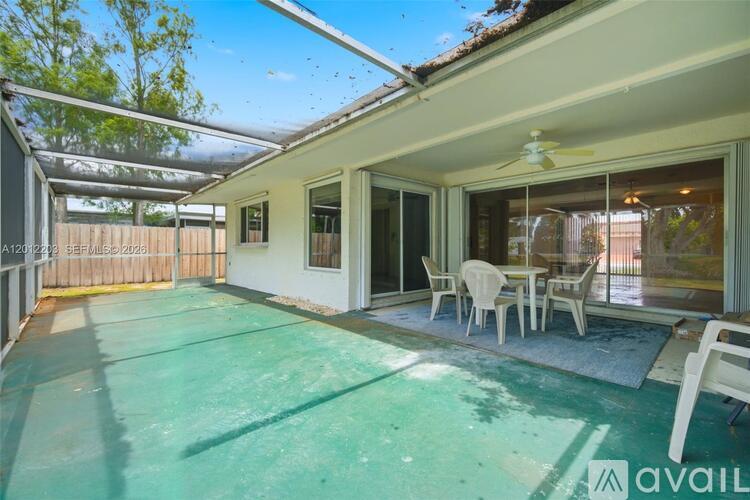 A patio with a table and chairs is covered with a green tarp.