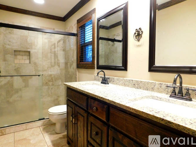 A bathroom with a marble countertop and a walk-in shower.