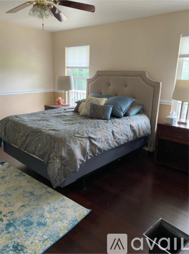 A bedroom with a large bed and a ceiling fan.