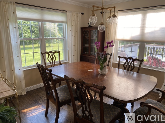 A dining room with a wooden table and chairs.