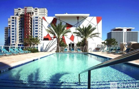 A pool in front of a building with a white and red design.