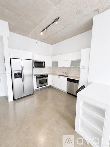 A modern kitchen with white appliances and cabinets.