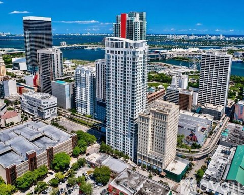 A cityscape with a mix of modern and older buildings, with a clear blue sky above.