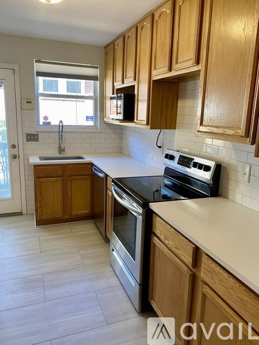 A kitchen with wooden cabinets and a white countertop.