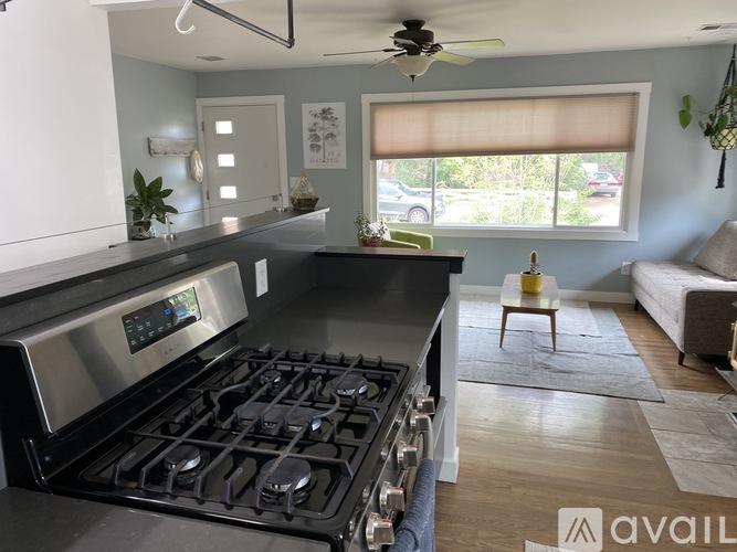 A modern kitchen with a stainless steel stove and a ceiling fan.
