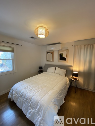 A bedroom with a bed, nightstand, and lamp.