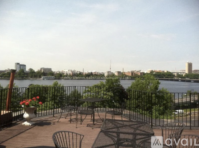 A patio with a table and chairs overlooking a river.
