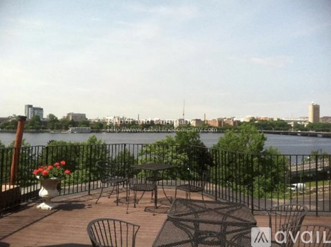 A patio with a table and chairs overlooking a river.