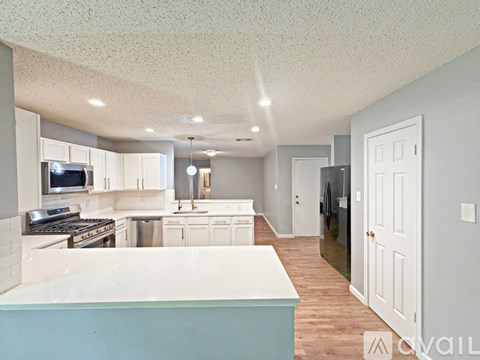 A kitchen with white cabinets and a blue island.