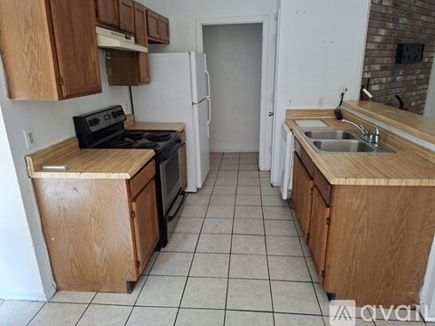 A kitchen with wooden cabinets and a black stove top oven.