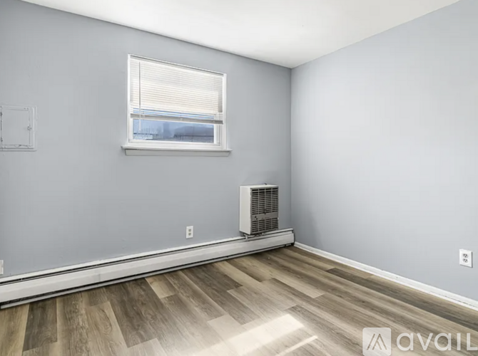 A room with a window and a wall-mounted air conditioning unit.