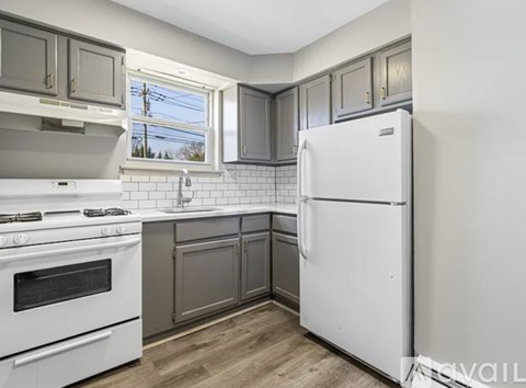 A kitchen with a white refrigerator, white stove, and white oven.