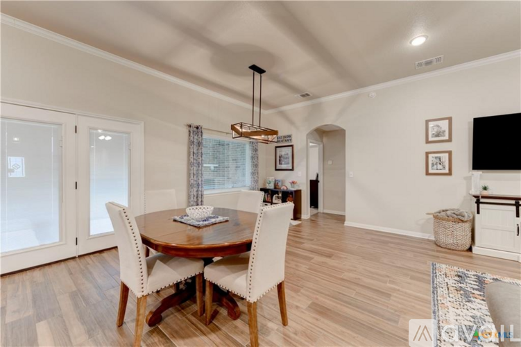 A dining room with a round table and chairs.