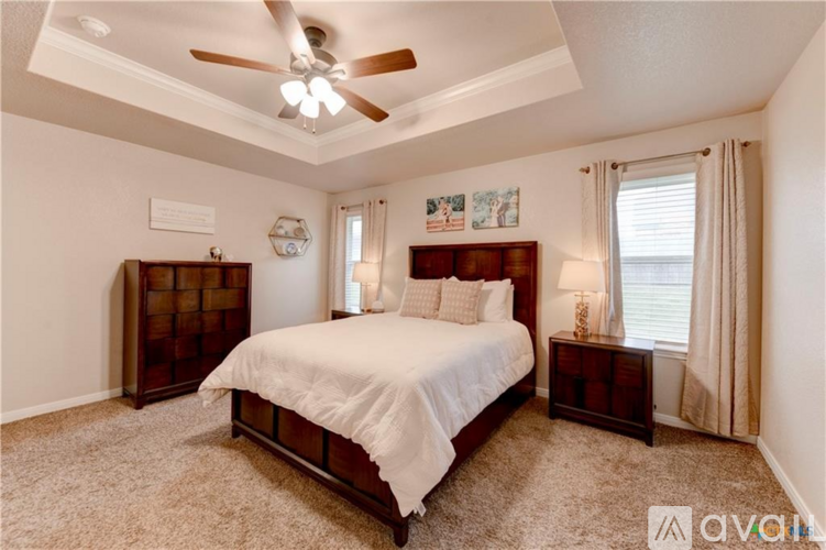 A bedroom with a bed, nightstand, and a ceiling fan.
