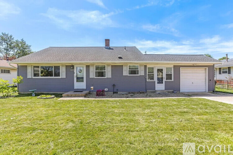 A house with a grey roof and a white garage door is for sale.