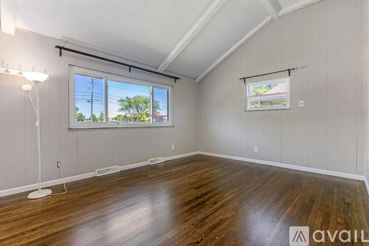 A room with wooden floors and a window showing a view of the outside.