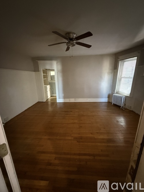 A room with wooden floors and a ceiling fan.